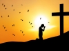 Christian background: man praying under the cross